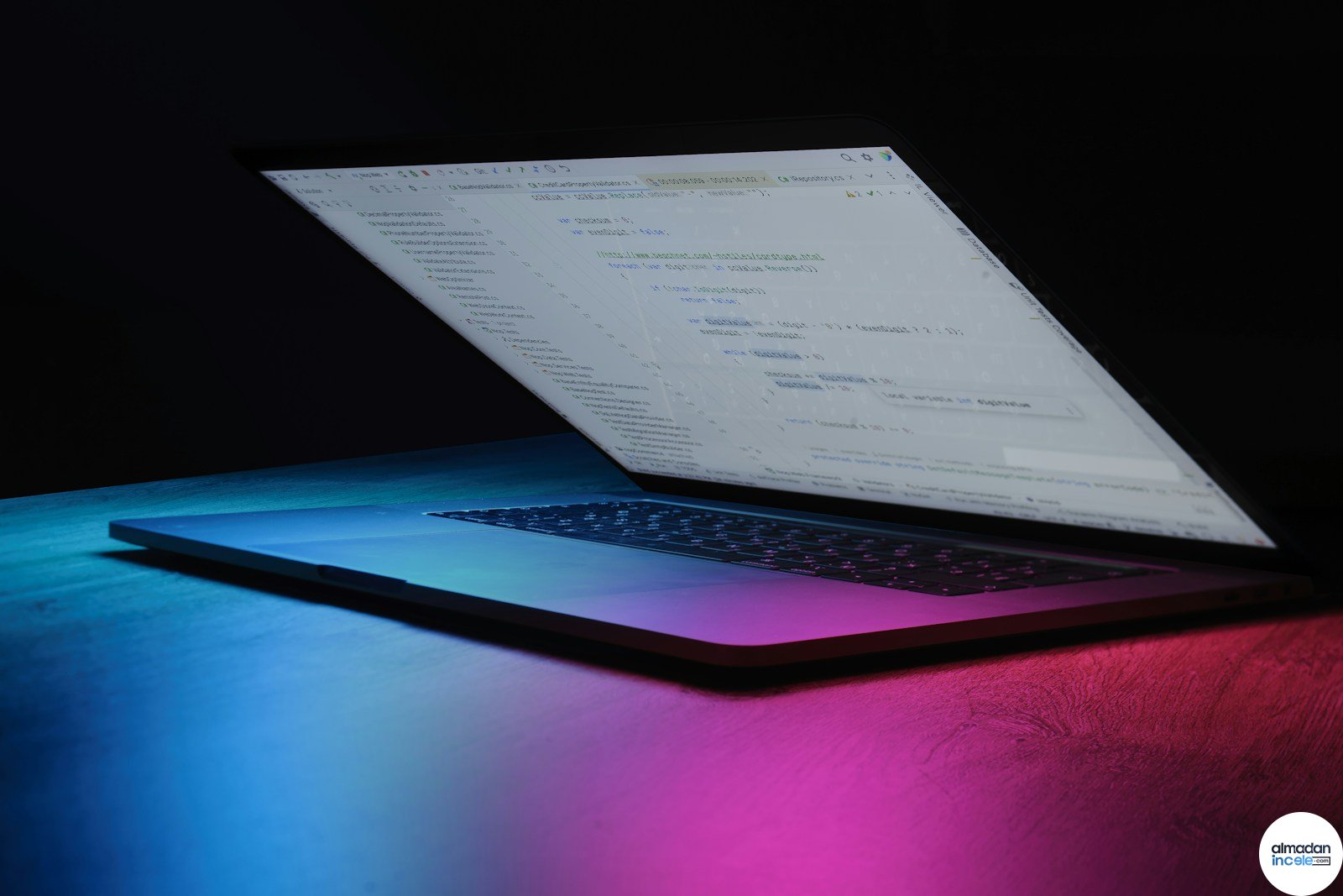 Neon ışıklı ekranda kod görünen laptop, yapay zeka ve yazılım geliştirme teması