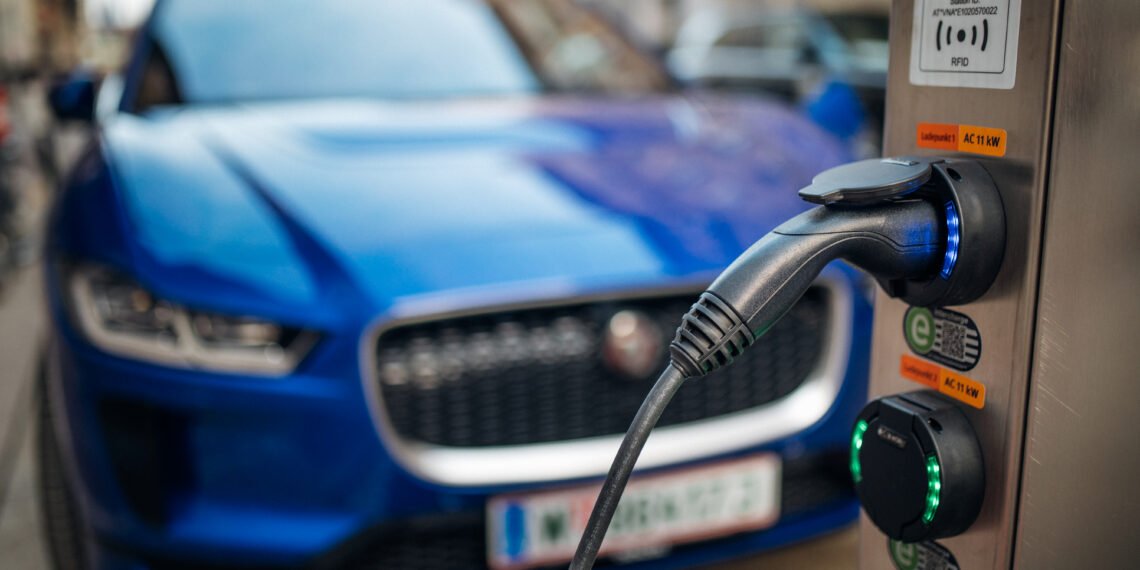 Elektrikli araç şarj istasyonu ve arkada elektrikli otomobil