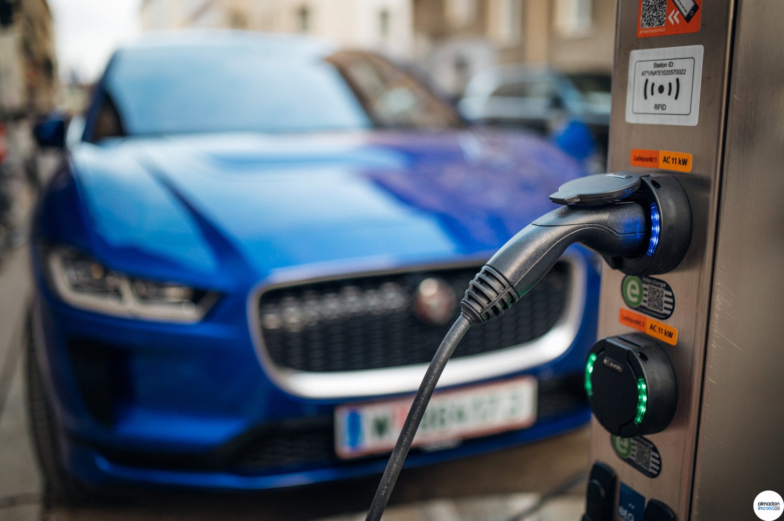 Elektrikli araç şarj istasyonu ve arkada elektrikli otomobil
