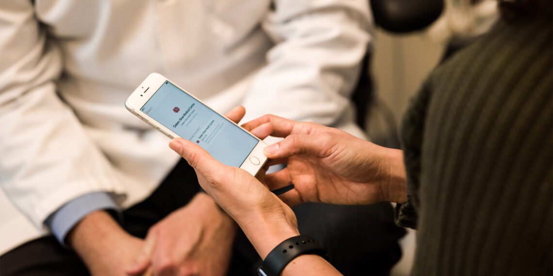 Doktor ve hasta yanında iPhone üzerinde Apple Health sağlık kayıtları