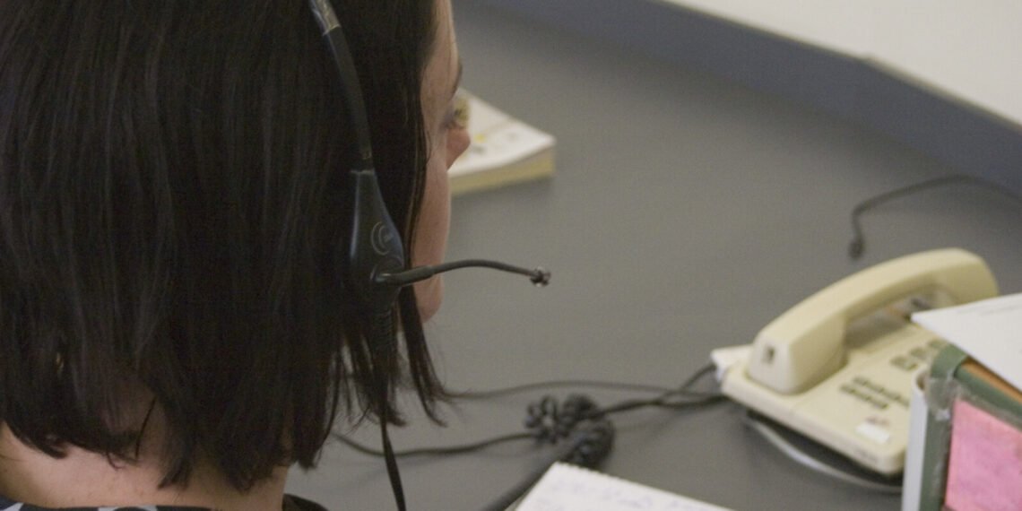 Ofiste telefon kulaklığıyla müşteri desteği veren çalışan