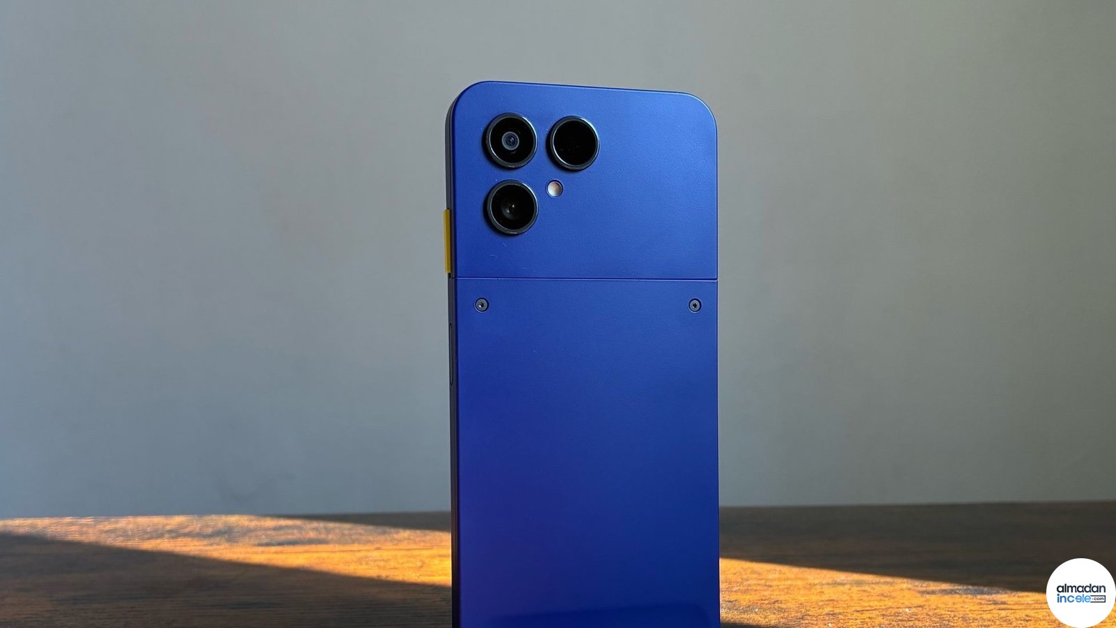 Masa üzerinde duran mavi Fairphone Gen 6+ telefonun arka kamera ve modüler kapak görünümü