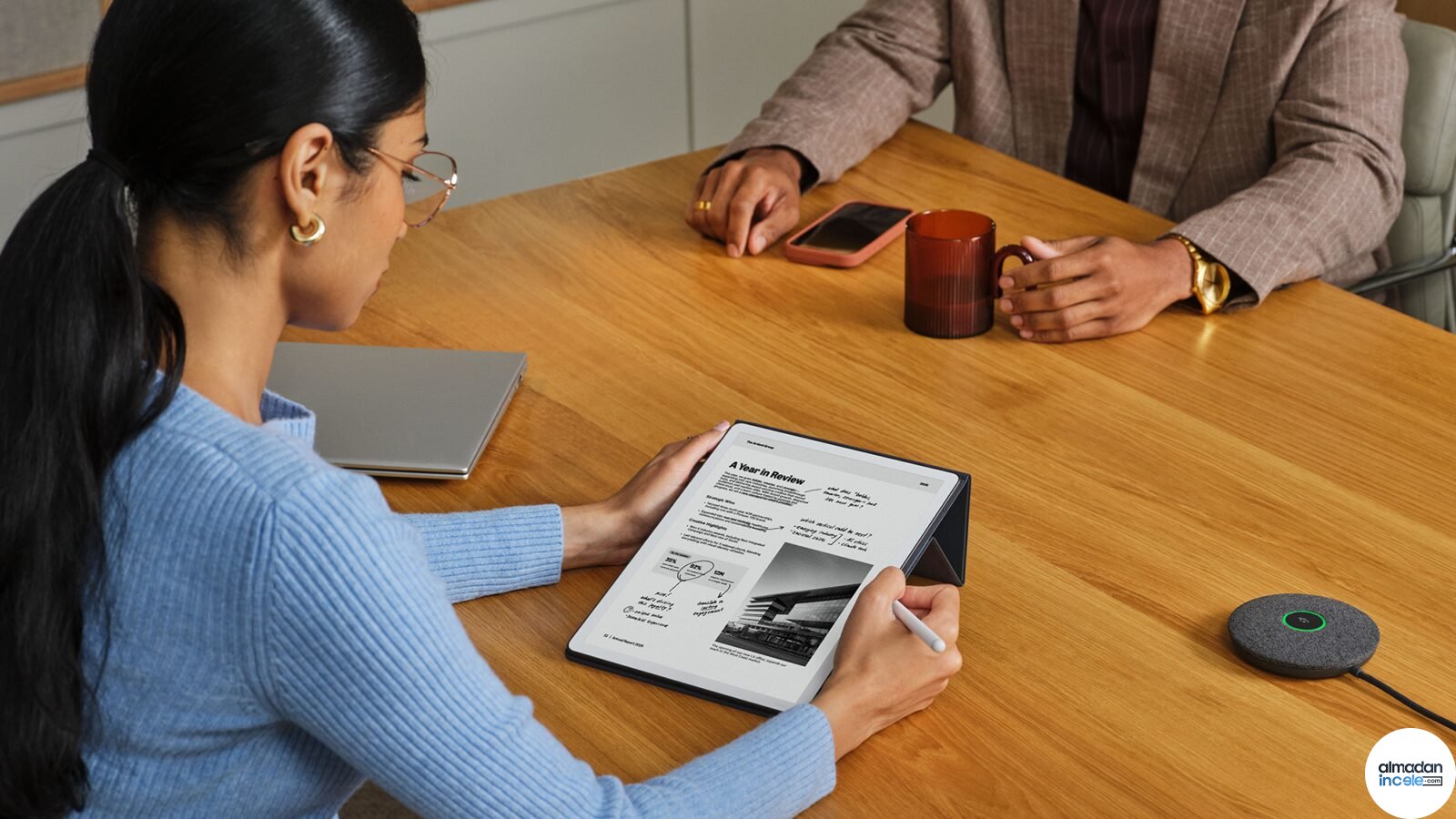 Toplantı masasında Kindle Scribe Colorsoft ile kalem kullanarak not alan kişi