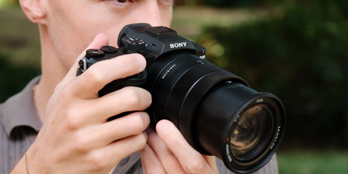 Doğa ortamında Sony RX10 V fotoğraf makinesiyle çekim yapan fotoğrafçı