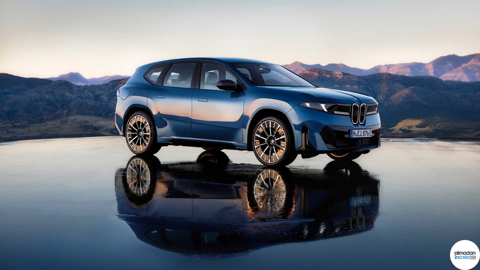 Dağlık manzara önünde mavi BMW iX3 elektrikli otomobil