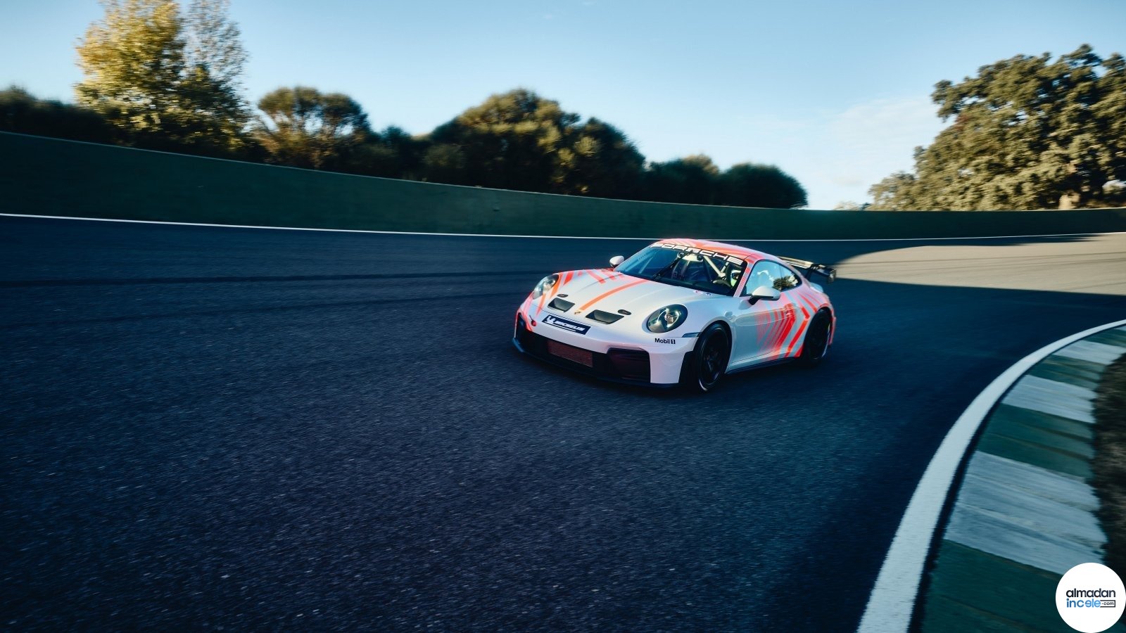 Yarış pistinde viraj alan Porsche 911 Challenge yarış otomobili