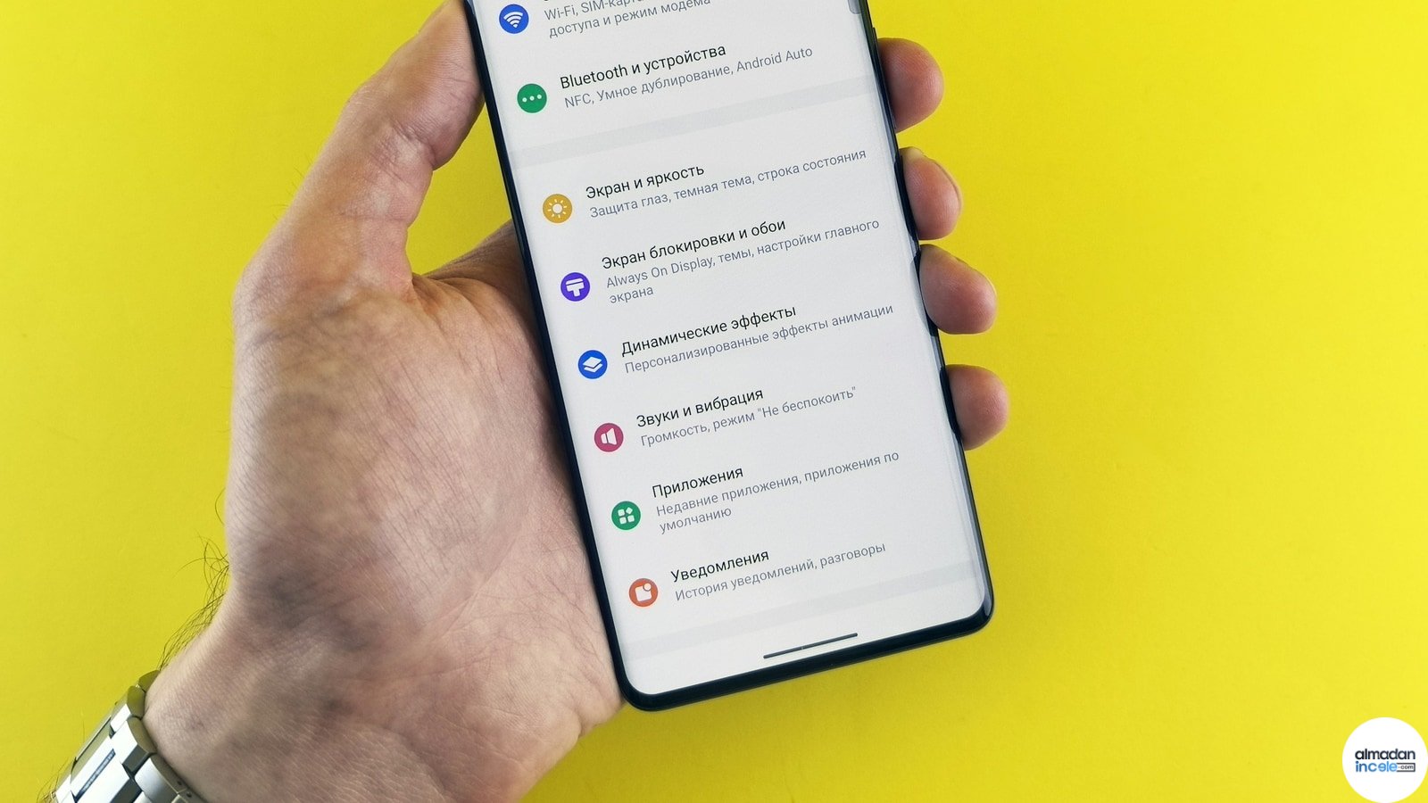 Ayarlar ekranı açık akıllı telefonu tutan el; Android güvenlik yaması kontrol adımlarını anlatan rehber görseli